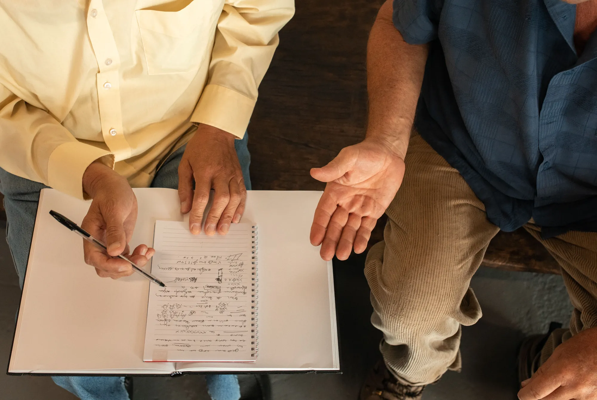A support worker and a man going through a written plan together